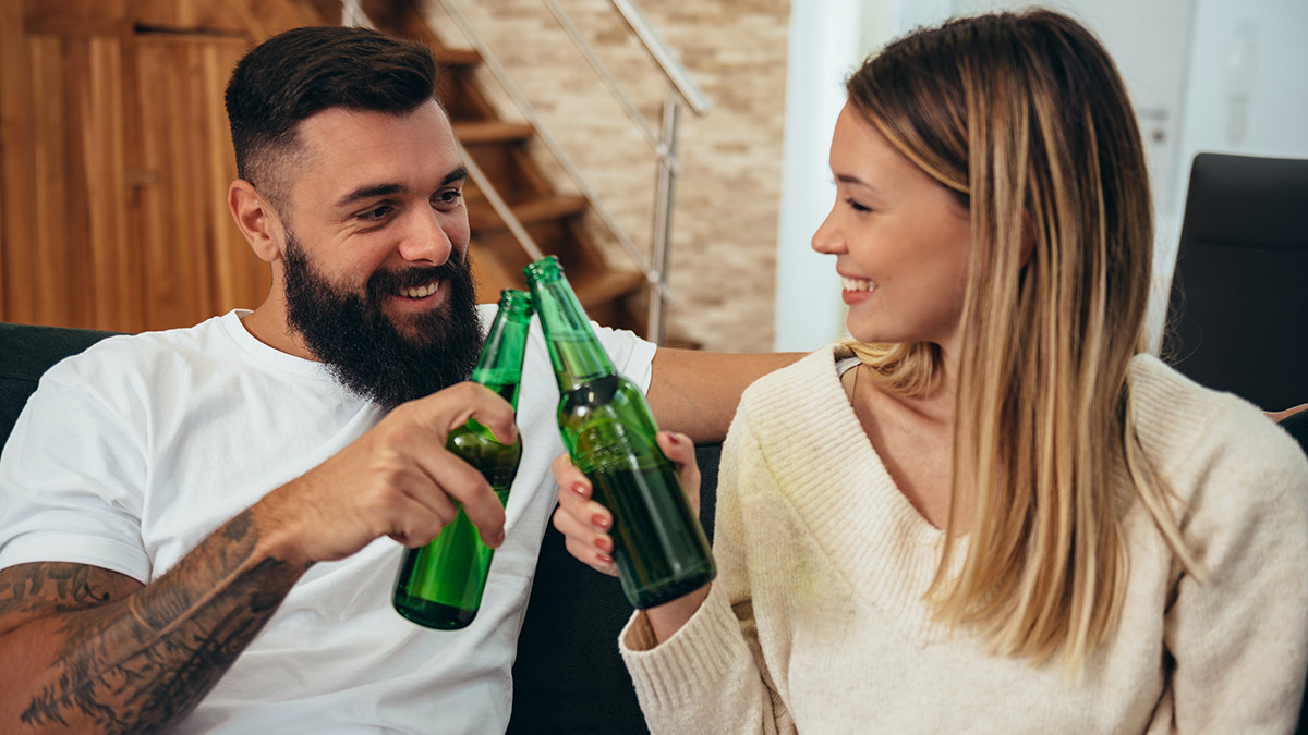 Pareja tomándose una cerveza en casa