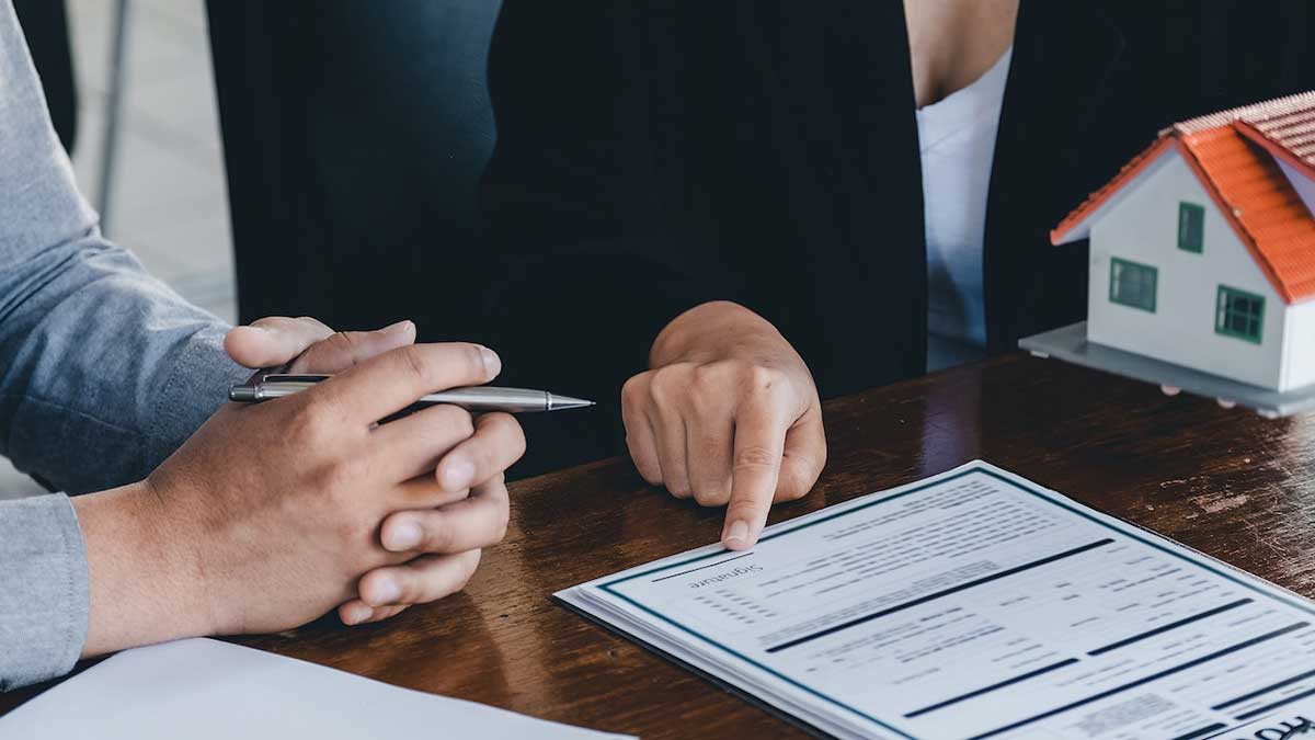 Dos personas firmando los términos de un contrato.