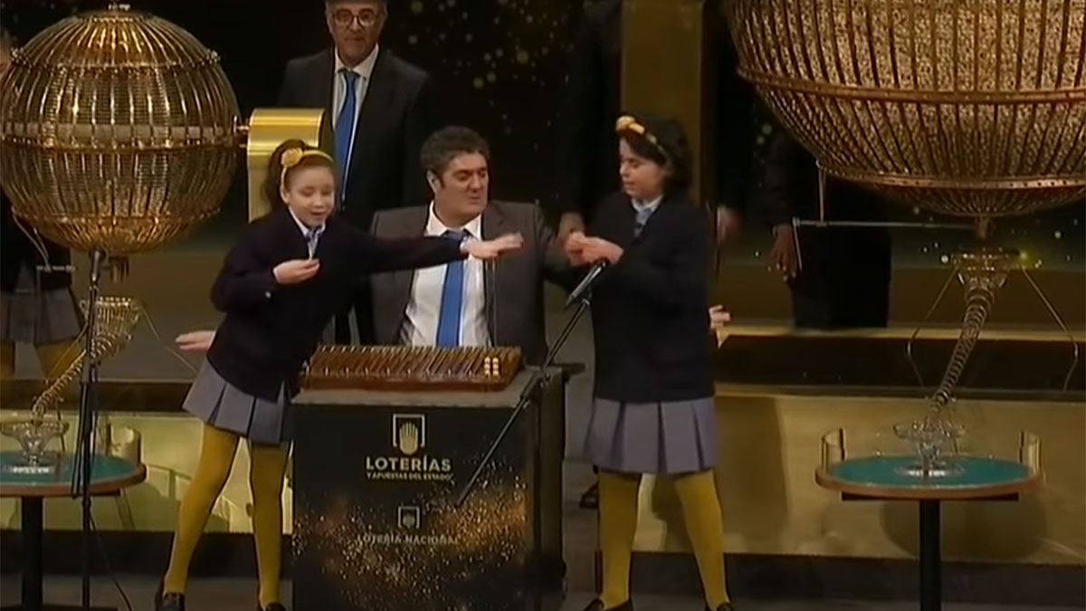 Dos niñas del colegio de San Ildefonso cantando la Lotería de Navidad.