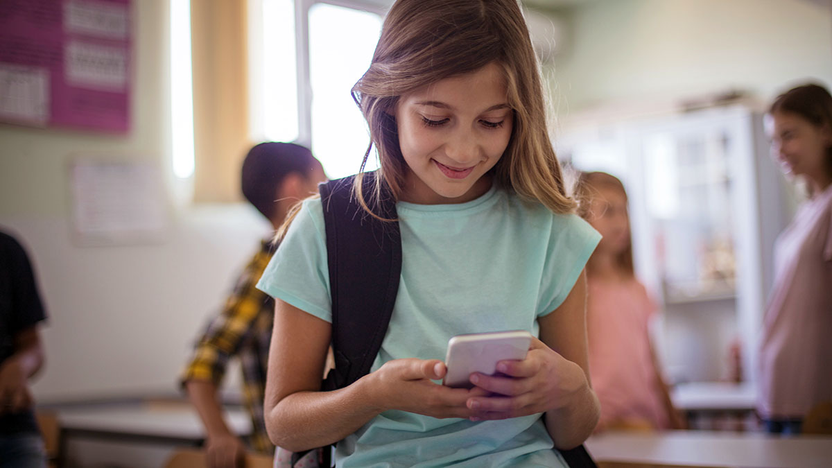 Niña con móvil en clase