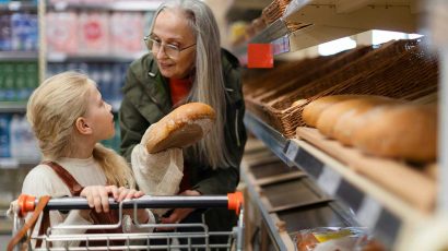 Una madre y una hija comprando pan sin gluten en el supermercado.
