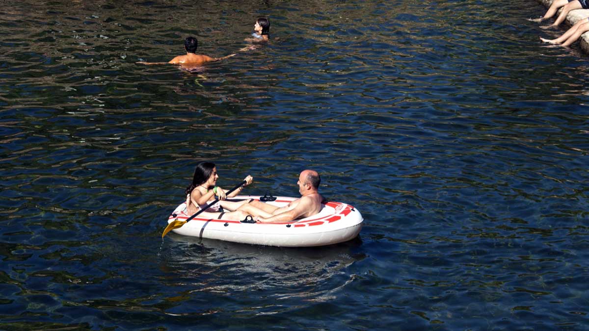 Una familia en barca en la piscina de Acebo.