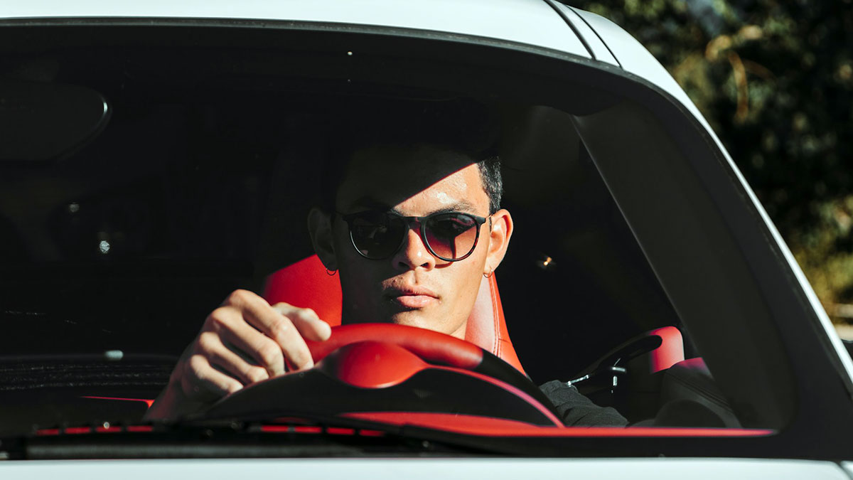 Un hombre conduciendo con gafas de sol prohibidas.