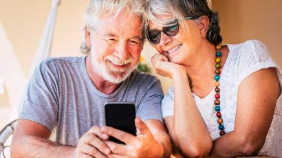 Una pareja de jubilados mirando el móvil.
