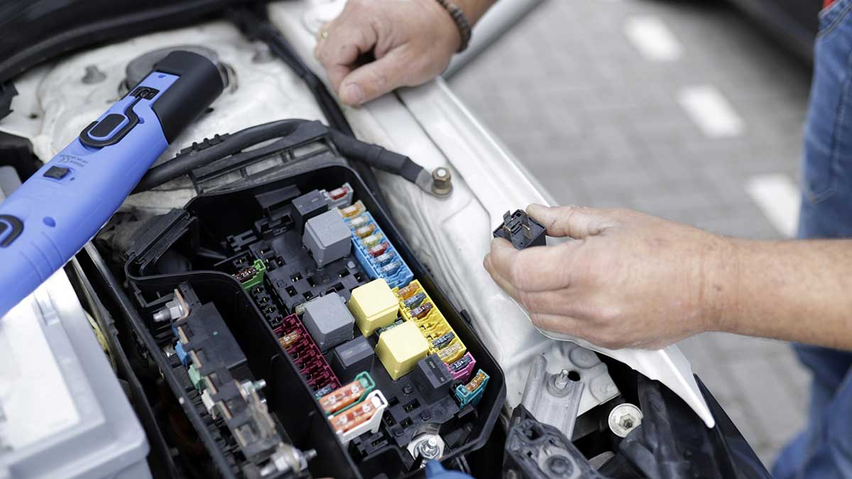 Mecánico arreglando la batería del coche.