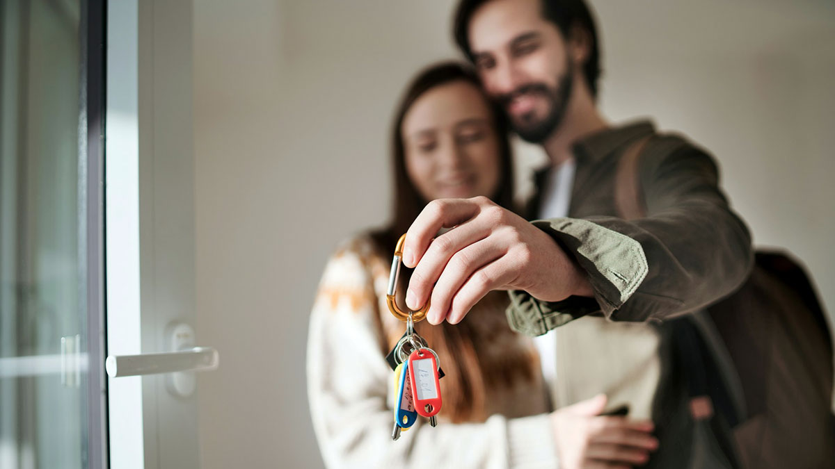 Una pareja con las llaves de su nueva casa.