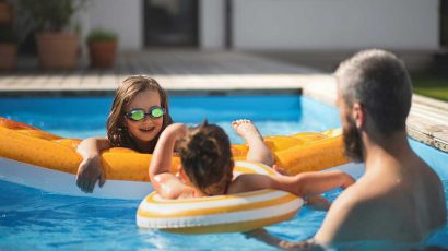 Una familia disfruta de una piscina en su vivienda.