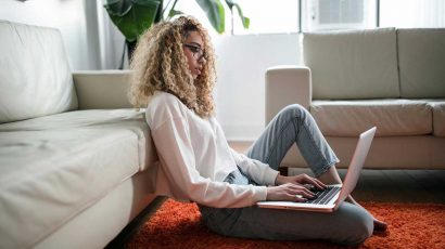 Una persona en casa teletrabajando con su ordenador portátil.