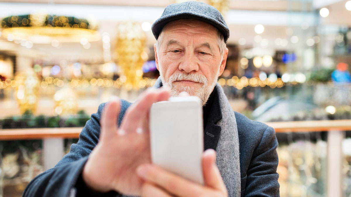 Un hombre mayor haciéndose un selfie con el móvil.