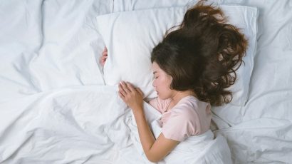 Una mujer durmiendo mientras abraza la almohada.