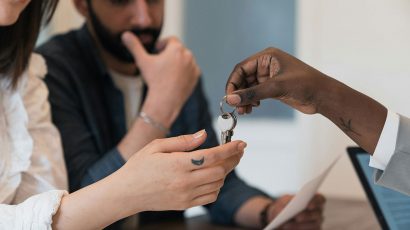 Una pareja recibiendo las llaves de su nueva casa.