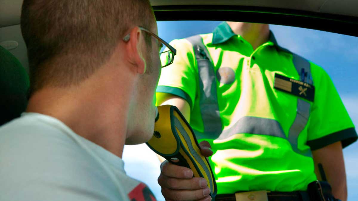 Una agente de la Guardia Civil realizando un control de alcoholemia a un conducotr.