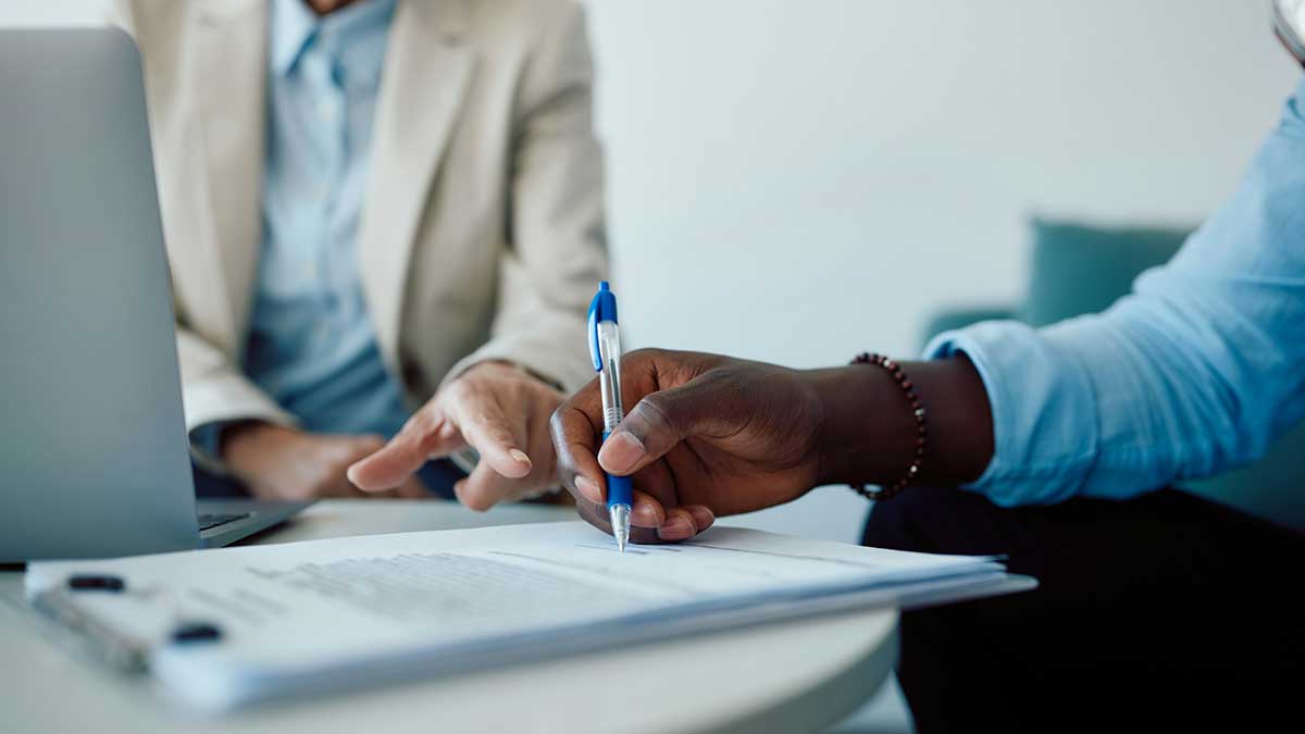 Una persona firmando un documento.