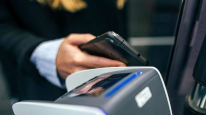 Una mujer acercando el móvil al lector de un autobús público.