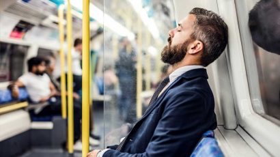 Un hombre agotado se queda dormido en el metro.