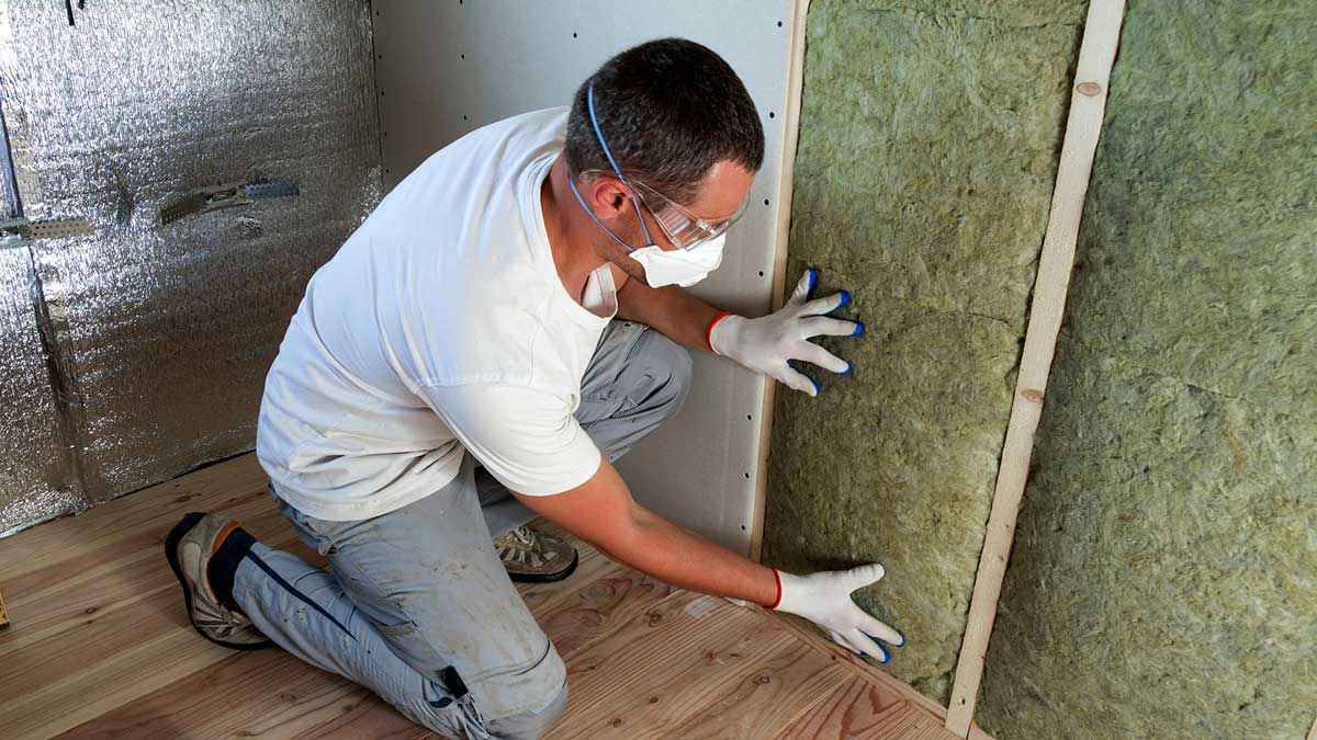 Un operario aísla una pared con lana de roca.