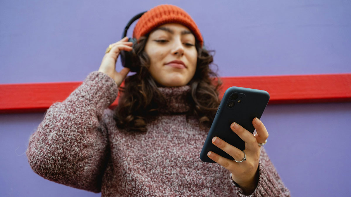 Una mujer con cascos inalámbricos escuchando música.