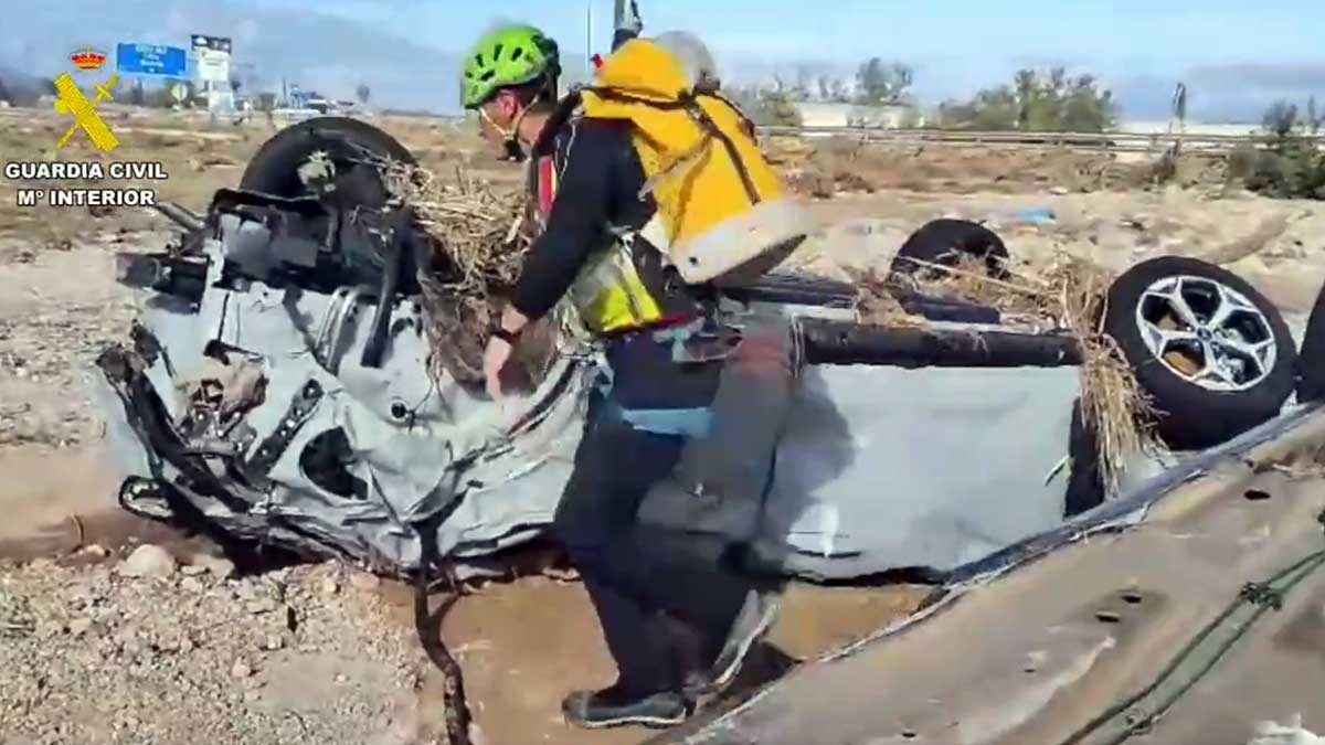 Un Guardia Civil de montaña busca desaparecidos entre los coches afectados por la DANA.