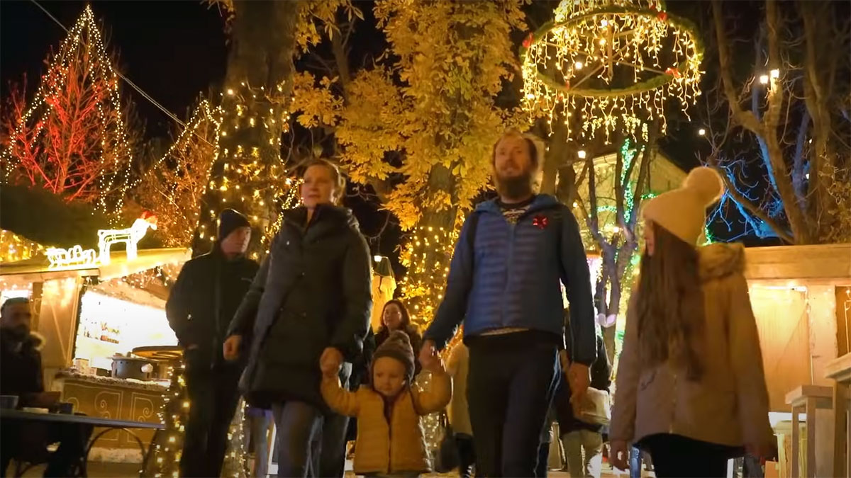 Una familia paseando por el parque de Mágicas Navidades de Torrejón de Ardoz, Madrid.