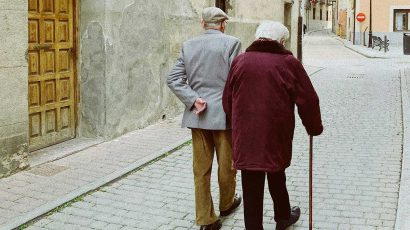 Una matrimonio de jubilados pasea por la calle.