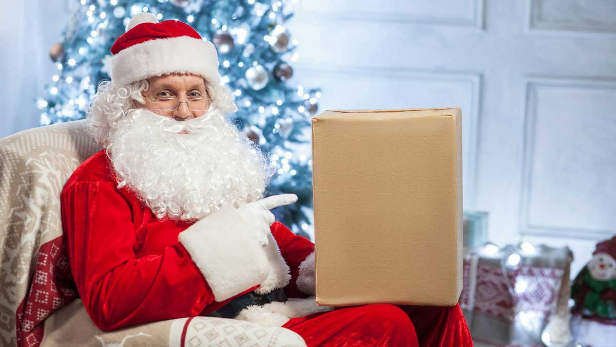 Santa Claus en su casa de Laponia preparando un regalo de Navidad.