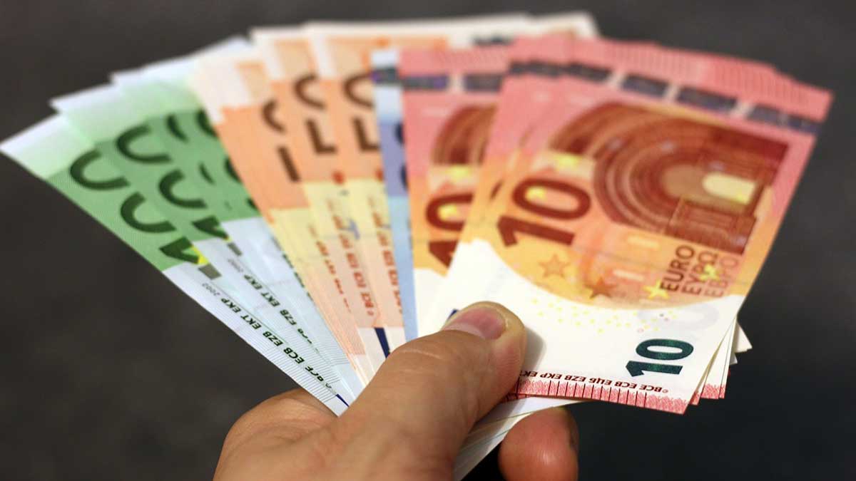 Una persona sujetando billetes de euro en forma de abanico.