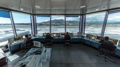 Controladores aéreos desempeñando su trabajo en una torre de control en un aeropuerto.