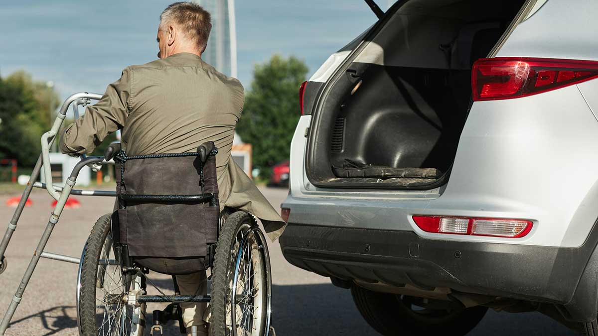 Una persona en silla de ruedas subiendo a su coche.