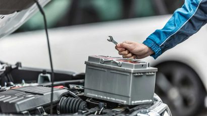 Un mecánico arreglando la batería de un coche.