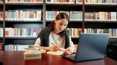 Una chica estudiando en la biblioteca.