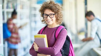 Una joven estudiante con libros en la universidad.