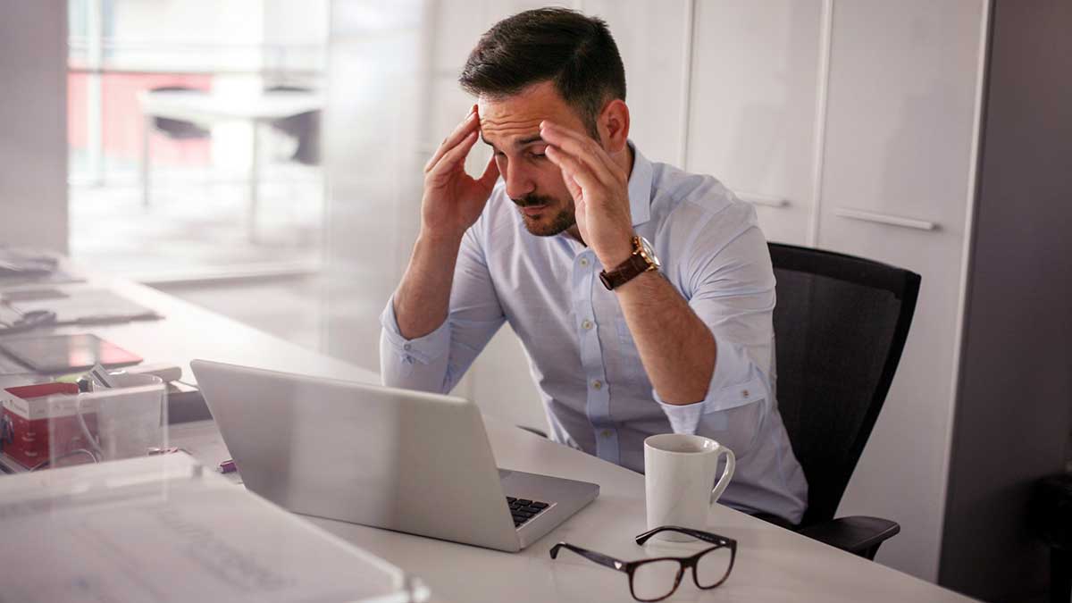 Una persona trabajando en la oficina y sufriendo ergofobia o miedo al trabajo.