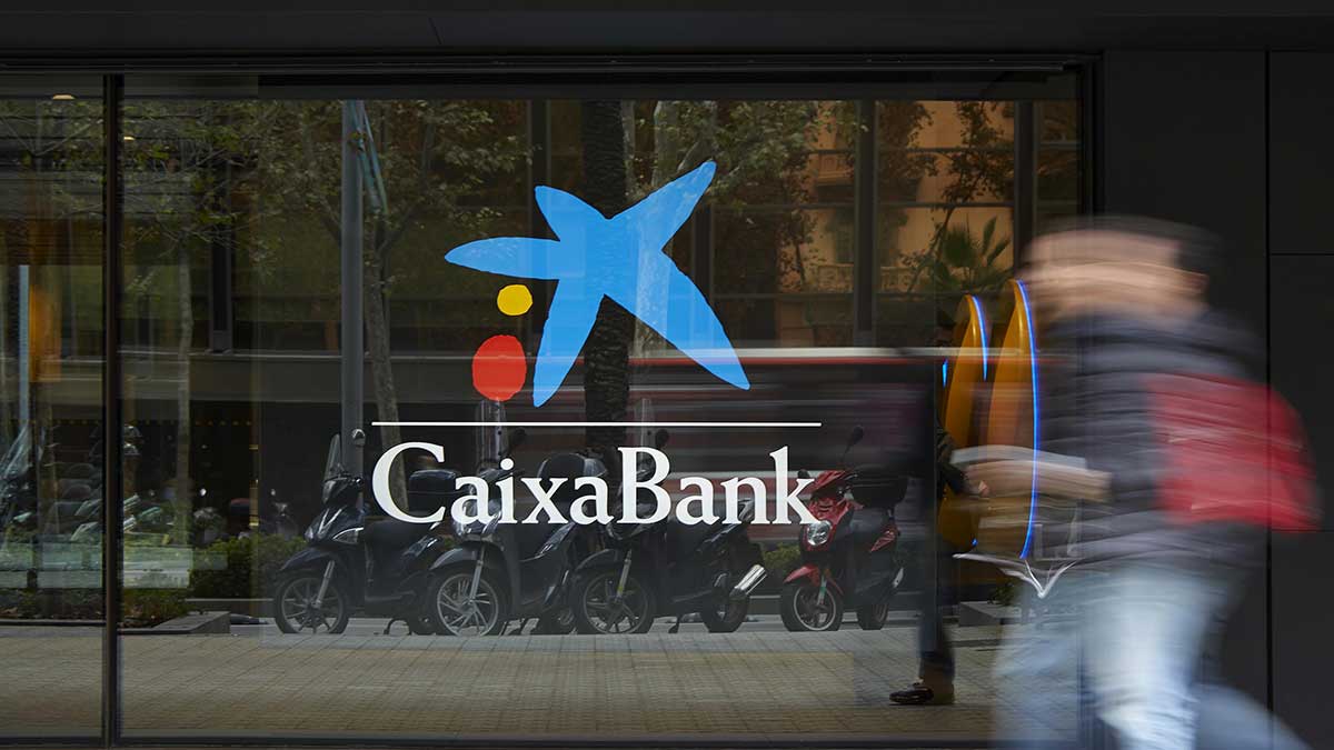 Un transeúnte pasa por delante de una oficina de CaixaBank.