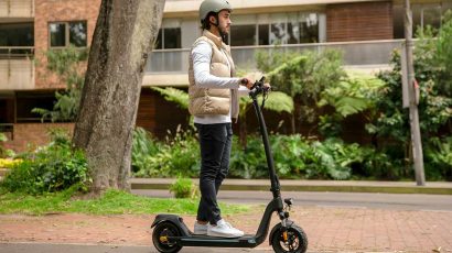 Un hombre circulando con el patinete eléctrico por la calle.