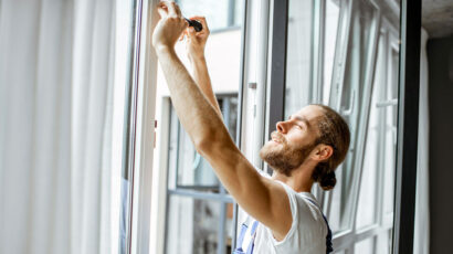 Un hombre instalando una ventana en casa.